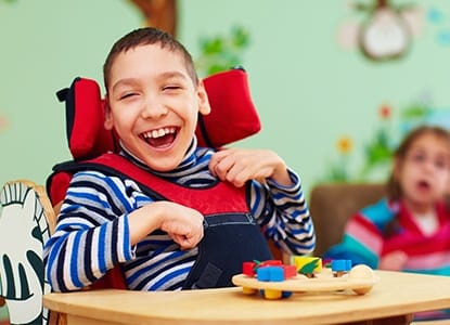 Laughing young boy in wheelchair
