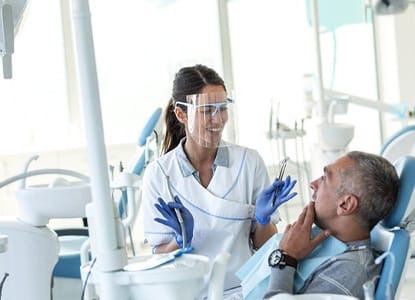 A dentist speaking with a dental patient.