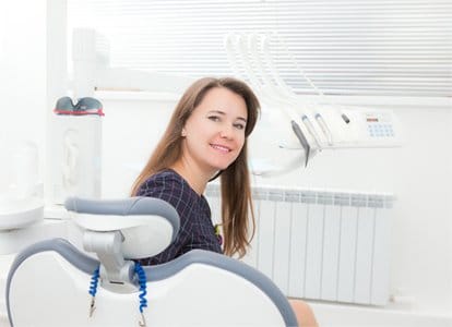 Calm dental patient turning to look behind dental chair