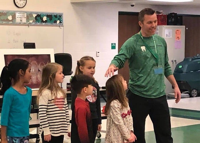 Dentist giving school children a tour of the office