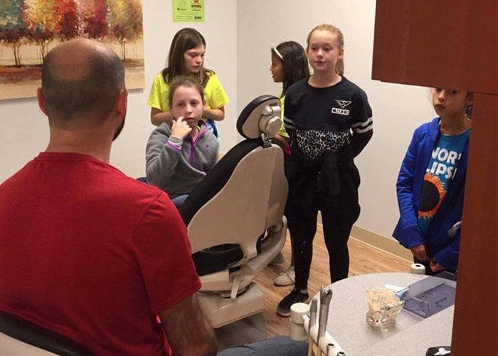 Dentist and children in dental exam room