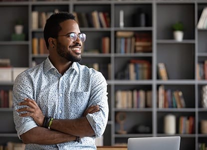 person smiling with their arms crossed