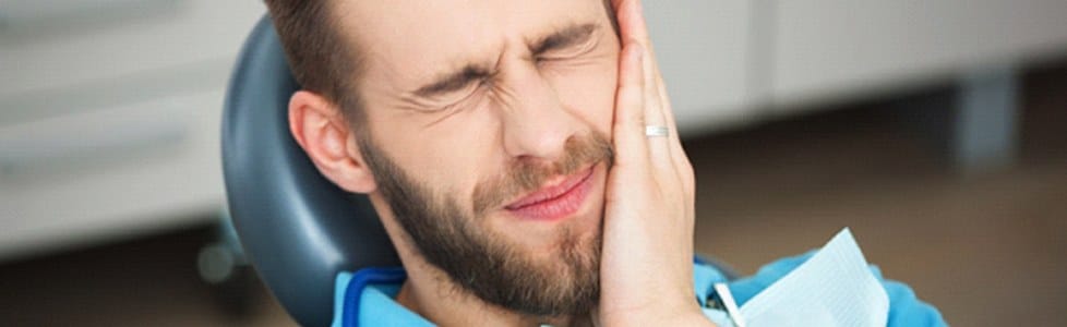 A young man with dental pain at a dental office.