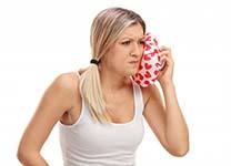 woman holding a cold compress to her cheek