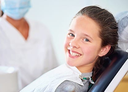 Child in dental chair smiling