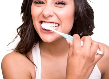 A woman brushing her dental crown in Teays Valley.