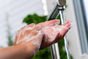 Patient practicing excellent hand hygiene as recommended by St. Albans dentist